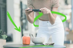 Una food influencer italiana mentre scatta una foto a un barattolo di succo e a una ciotola.